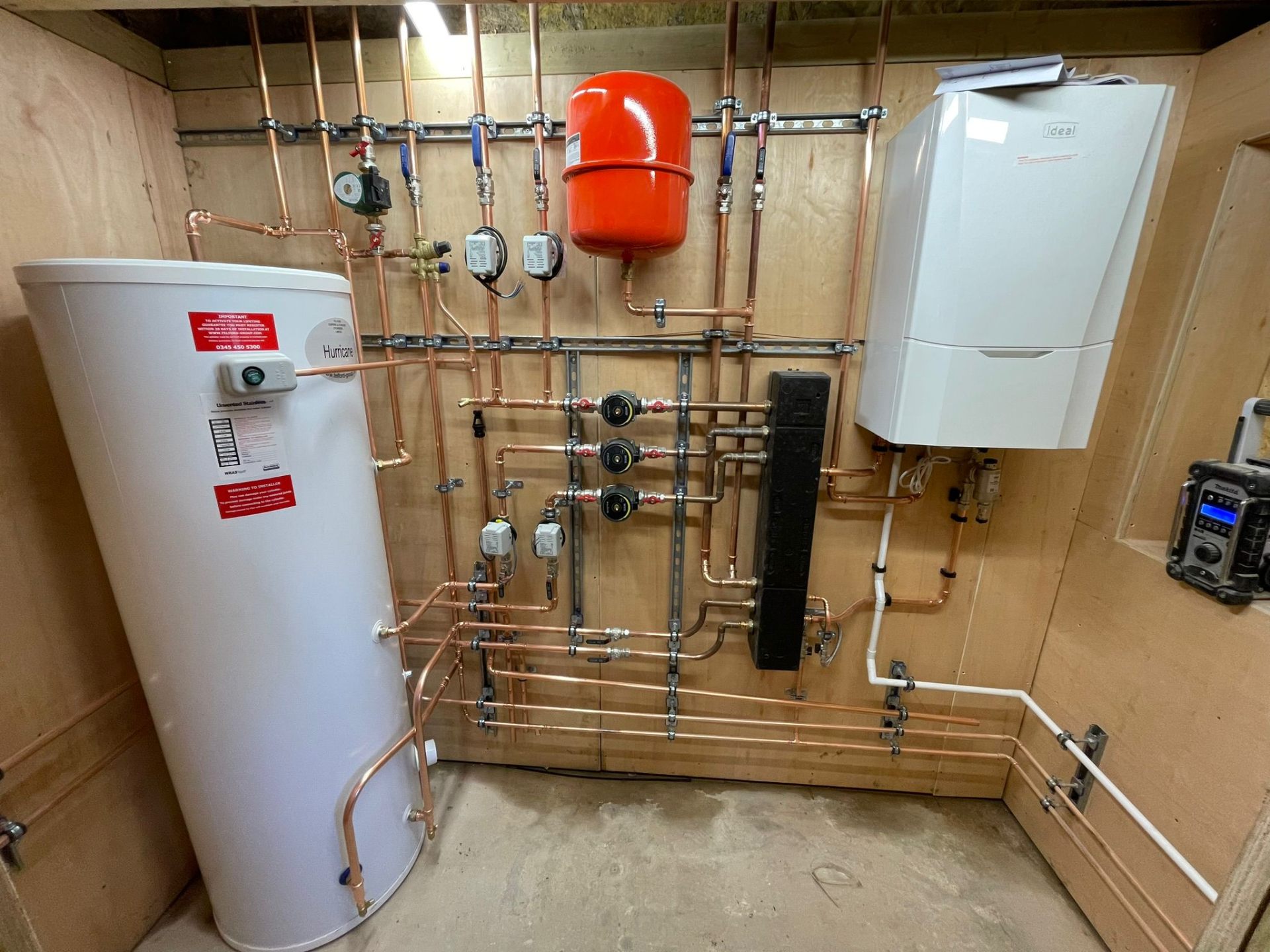 Complete central heating plant board with unvented cylinder, low-loss header and zoned pump group